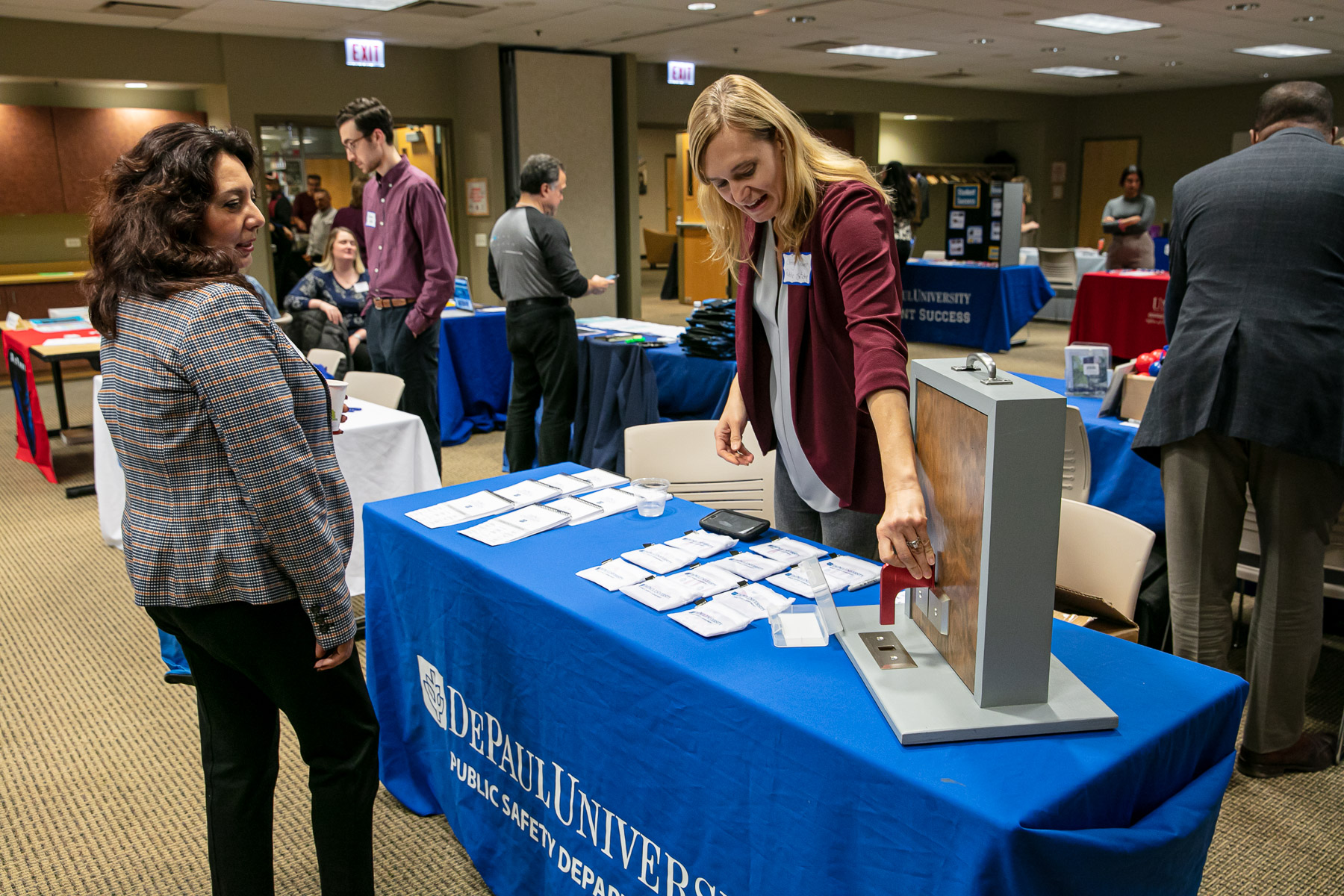 Cheryl Hover, associate director of emergency management in Facility Operations and Public Safety, demonstrates the proper use of the Nightlock Lockdown door stopper in classrooms during the Adjunct Faculty Resource Fair. (DePaul University/Randall Spriggs)